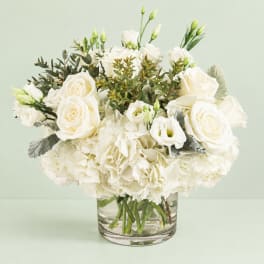 White roses and lisianthus in a clear glass vase