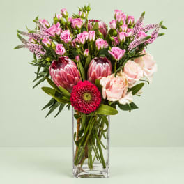 Pink and cream mixed bouquet in a clear rectangular vase