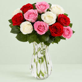 Bouquet of red, pink, and white roses in a clear glass vase
