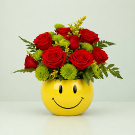Red roses and green mums in a yellow smiley-face vase