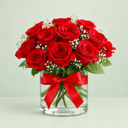 Red roses in a glass vase with a red ribbon