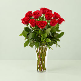 Red roses arranged in a clear glass vase