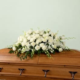 White rose arrangement on a wooden casket