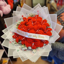 Bouquet of bright orange flowers wrapped in translucent paper