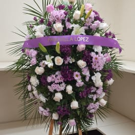 Standing floral spray with white and lavender flowers and a purple ribbon banner