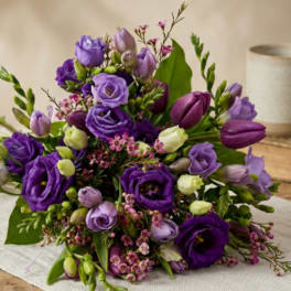 Purple and lavender bouquet with tulips and lisianthus on a table