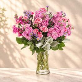 Pink and purple mixed bouquet in a clear glass vase
