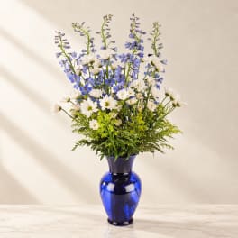 Blue and white flower arrangement in a cobalt glass vase