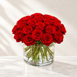Red roses arranged in a clear glass vase