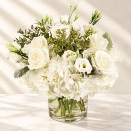 White roses and carnations in a clear glass vase