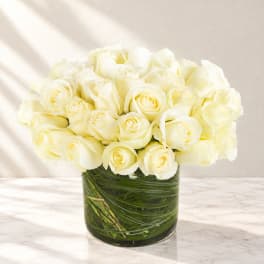 White roses arranged in a clear glass vase