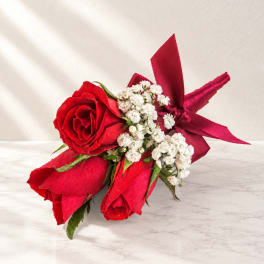 Red rose bouquet with white filler flowers and a burgundy ribbon wrap