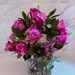 Pink roses arranged in a clear square glass vase