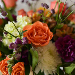 Close-up bouquet with orange roses and purple flowers