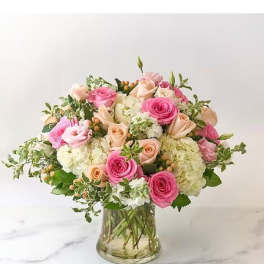 Pink and peach roses with white hydrangeas in a glass vase