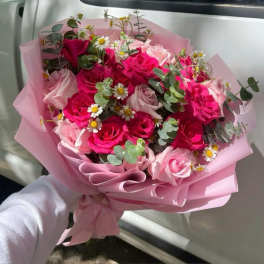 Pink rose bouquet with small white daisies wrapped in pink paper