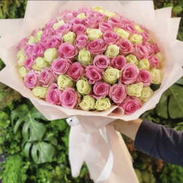 Large bouquet of pink and pale yellow roses wrapped in blush paper