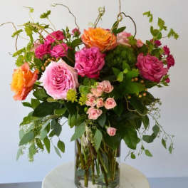 Mixed pink and orange roses in a clear glass vase