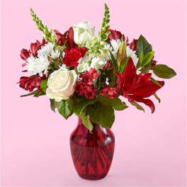 Bouquet of red and white flowers in a red glass vase