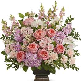 Pink roses and mixed pastel flowers arranged in a dark vase