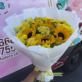 Bouquet of yellow sunflowers and roses wrapped in white paper
