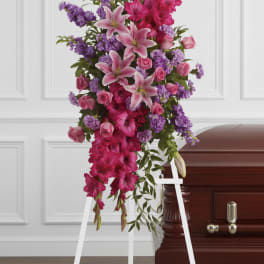 Standing funeral spray with pink lilies, roses, and purple flowers