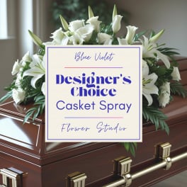 White casket spray with lilies and roses on a wooden casket