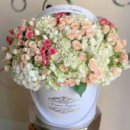Large bouquet of pink and cream roses in a white hatbox