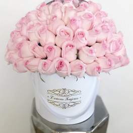 Pink roses arranged in a white hatbox with gold lettering