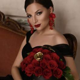 Woman holding a bouquet of red roses in a black box
