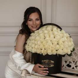 Woman holding a large black box filled with cream roses