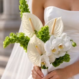 Bride holding a bouquet of white calla lilies, orchids, and green flowers