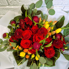 Bouquet of red roses, burgundy dahlias, and yellow tulips with eucalyptus