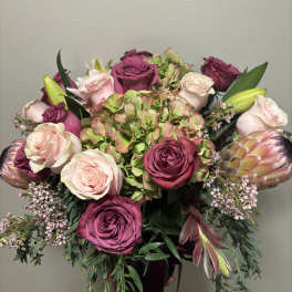 Bouquet of pink and magenta roses with hydrangea and protea