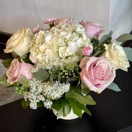 Pink and cream roses with white hydrangea in a low vase arrangement