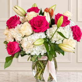 Bouquet of pink and white roses with lilies in a glass vase
