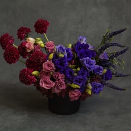 Bouquet of purple and pink flowers in a black container