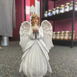 White angel figurine holding a small bird