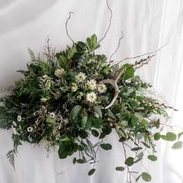 Large green floral arrangement with white daisy-like blooms and branching twigs