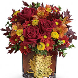 Autumn bouquet of red roses and mums in a decorative vase