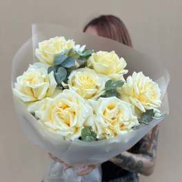 Bouquet of pale yellow roses wrapped in translucent paper