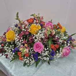 Large mixed bouquet with pink, yellow, and orange roses and small white filler flowers