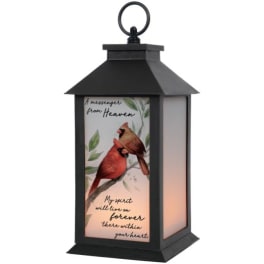 Black lantern with a cardinal memorial panel and warm light inside