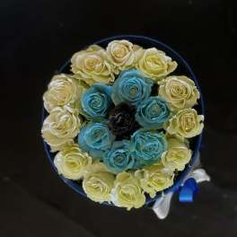 Round bouquet of pale yellow and blue roses with a ribbon wrap
