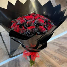 Bouquet of red roses wrapped in black paper with a red ribbon