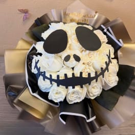 White rose bouquet with a skull face design and black-and-gold wrapping