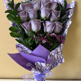 Bouquet of lavender roses with purple wrapping and ribbon