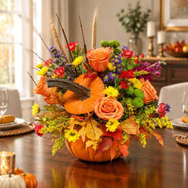 Pumpkin centerpiece with orange roses and mixed fall flowers