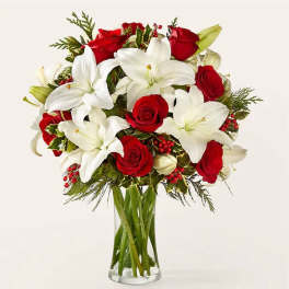 Bouquet of red roses and white lilies in a clear glass vase