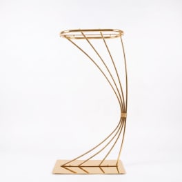 Gold metal floral stand with curved frame on a rectangular base